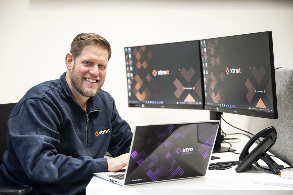 lachende medewerker achter pc bij xtrn-it